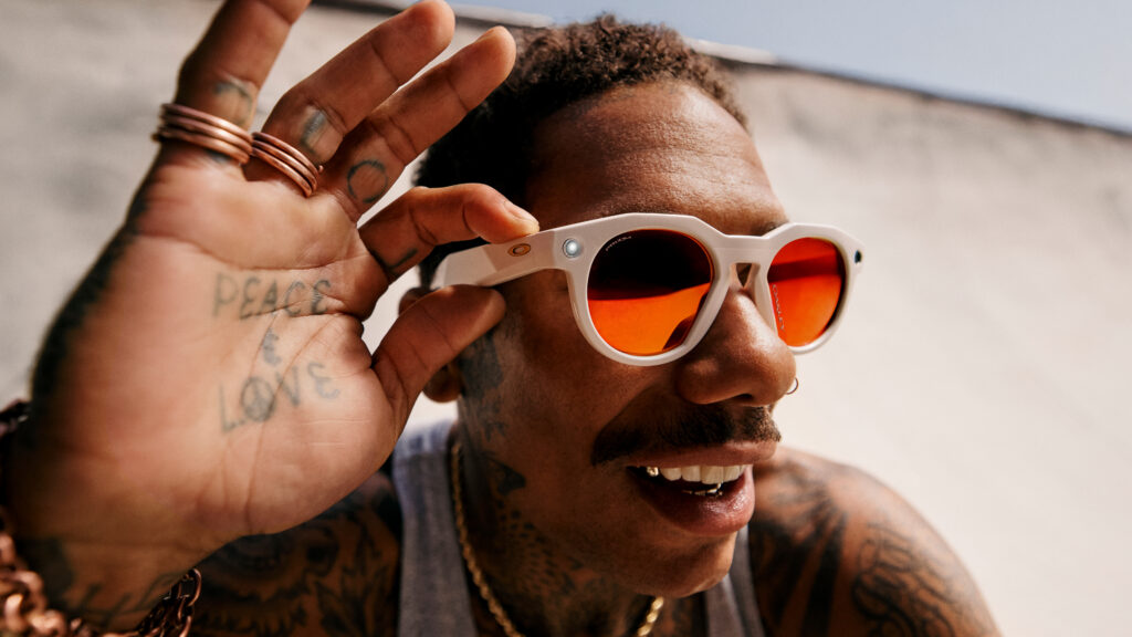 Boo Johnson portant les lunettes connectées Oakley Meta HSTN avec lentilles Prizm Ruby